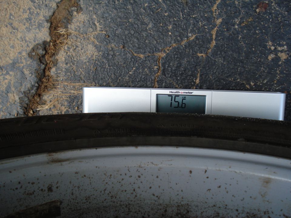 Tire on a scale showing 75.6 lbs