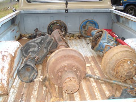 1967 Ford F-250 - Several rear axles and differential assemblies are loaded into the bed of a pickup truck.