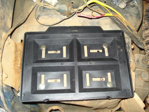1967 Ford F-250 - Close-up view of a black plastic component with four compartments and metal contacts, likely part of a vehicle's electrical system.