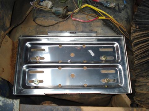 1967 Ford F-250 - Close-up of a shiny battery tray and electrical wiring in a vehicle's engine bay.