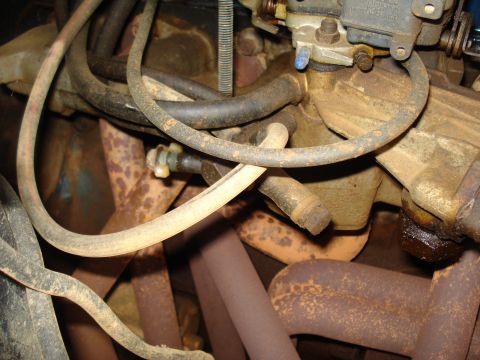 1967 Ford F-250 - Close-up view of engine components, including a carburetor and exhaust manifold, showing signs of age and rust.