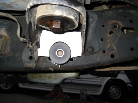 1989 Ford Bronco - Close-up view of a suspension component, possibly a body mount, with a template for modification.