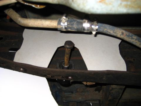 1989 Ford Bronco - A close-up view of a vehicle's undercarriage, showing a metal bracket and a hose.