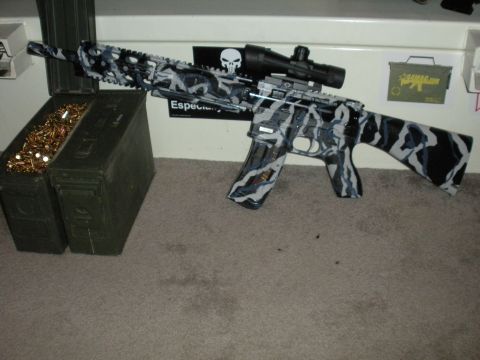 1996 Ford Bronco - An assault rifle with a custom camouflage paint job sits beside two ammunition cans filled with bullets.