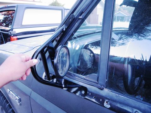 1986 Ford Bronco - Door mirror assembly on a 1986 Ford Bronco, with another vehicle in the background.