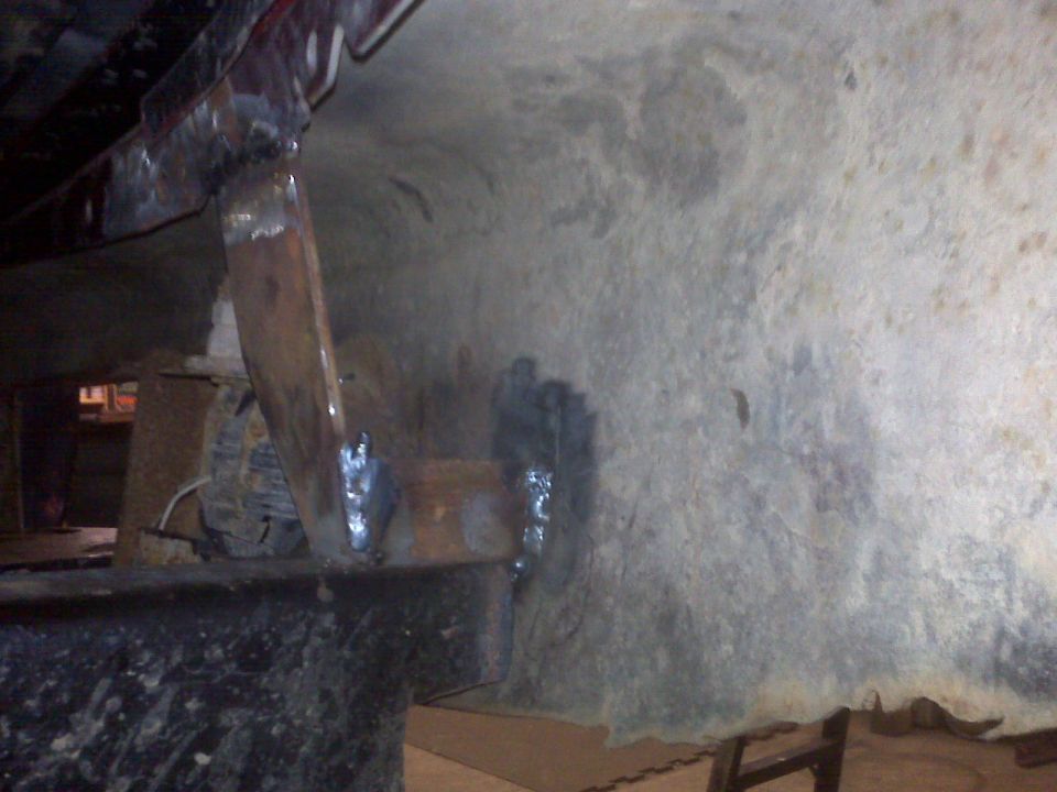 Undercarriage repair with visible welds and metal brackets