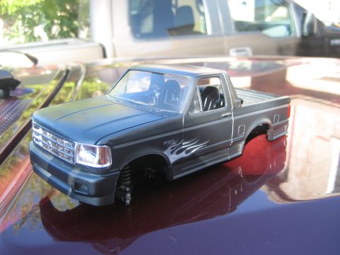 1993 Ford Bronco - Model truck body, possibly a 1992 Ford F-150, with flame decals and no wheels.