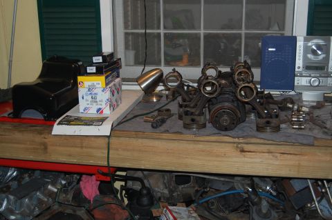 1994 Ford Bronco - Engine components and parts are organized on a wooden workbench, ready for assembly or repair.