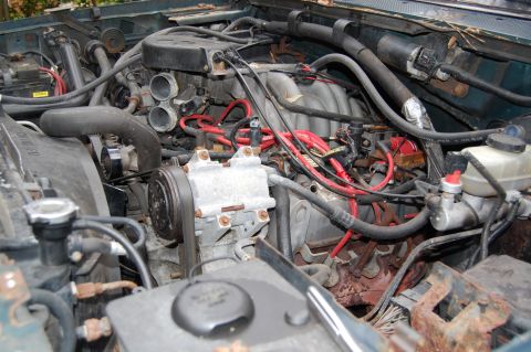 1994 Ford Bronco - Close-up view of a vehicle's engine compartment, showing the intricate network of hoses and wiring.