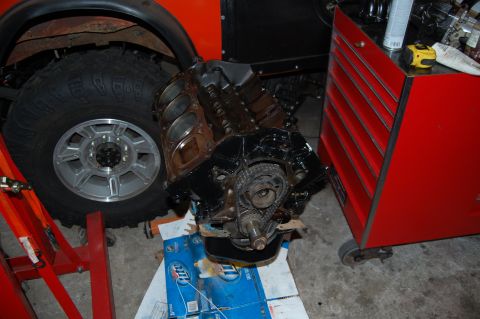 1994 Ford Bronco - An engine block sits on the floor near a tire and a red rolling toolbox in a garage setting.