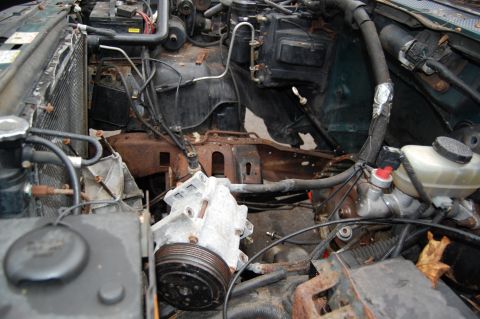 1994 Ford Bronco - The engine bay of a vehicle shows signs of disassembly, with various components exposed.