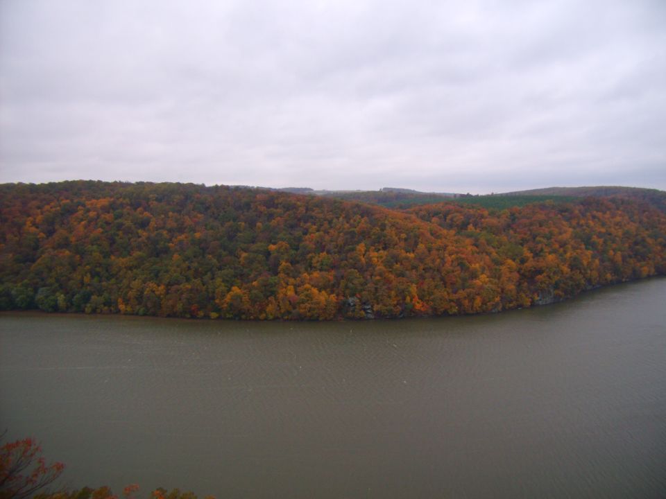 River flows past hills covered in autumn foliage