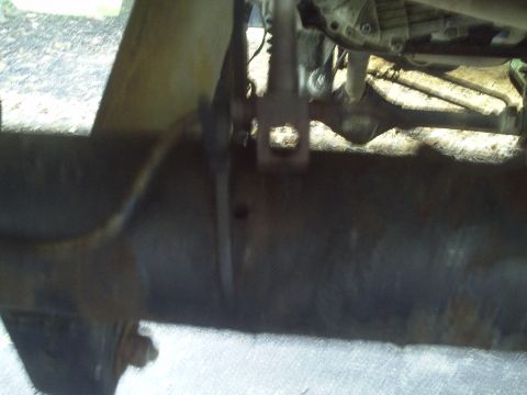 1990 Ford Bronco - Close-up view of the underside of a vehicle, showing mechanical parts and signs of wear.