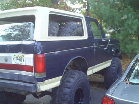 1990 Ford Bronco - This lifted Ford Bronco has oversized tires and spare tires stored in the back.