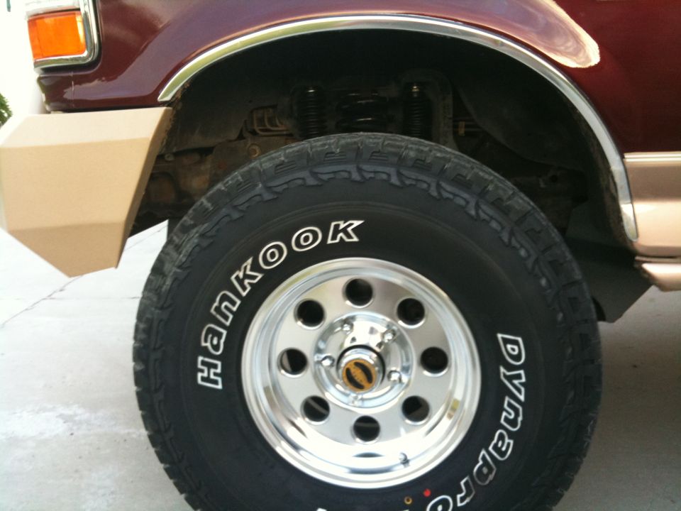 1996 Ford Bronco front fender, wheel, and tire. Burgundy paint, tan bumper, chrome wheel, Hankook Dynapro tire
