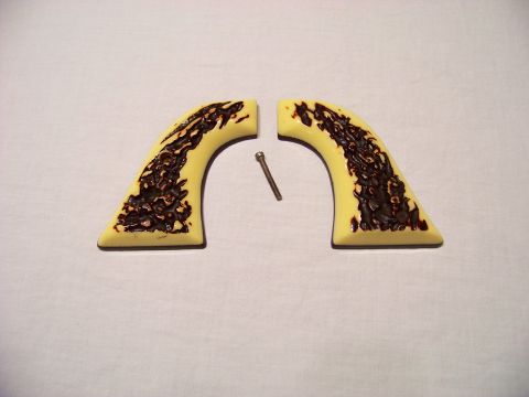1995 Mercury Grand Marquis - A pair of faux ivory gun grips and a screw are displayed against a white background.