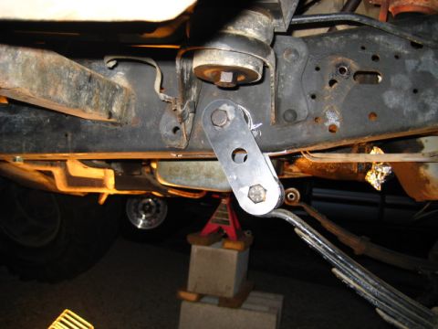 1989 Ford Bronco - Close-up view of a vehicle's undercarriage, focusing on suspension parts and a jack stand.