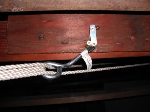1991 Ford Bronco - A close-up view of a rope and hook mechanism mounted to a wooden beam, likely for storage or lifting purposes.