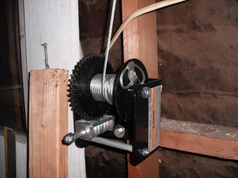 1991 Ford Bronco - Boat winch with a 2000 Lb capacity is mounted to wooden beams in a garage.