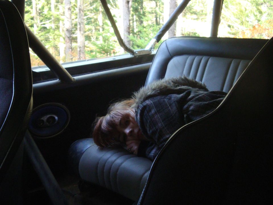 Interior view of a vehicle with a person sleeping on the seat