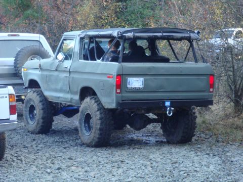 1978 Ford Bronco - This modified Ford Bronco is parked outdoors with other vehicles nearby, suggesting a gathering or event.