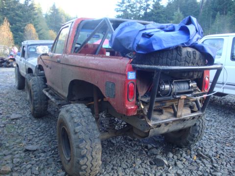 1978 Ford Bronco - Modified 1978 Ford Bronco seen in a gravel lot, equipped with a winch and spare tire carrier.
