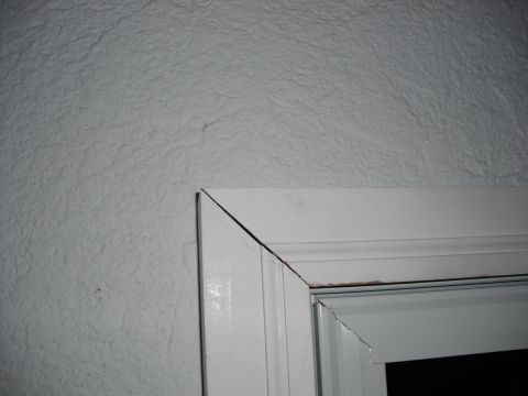 1991 Ford Bronco - The photo shows a close-up of a white door frame, with a textured wall visible to the left.