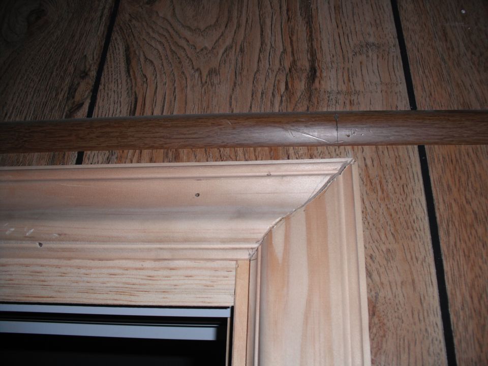 Unfinished wooden door frame with visible wood grain and trim details