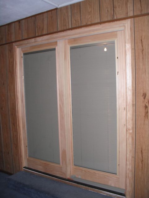 1991 Ford Bronco - Interior view of wooden framed sliding doors with blinds covering the glass panels.