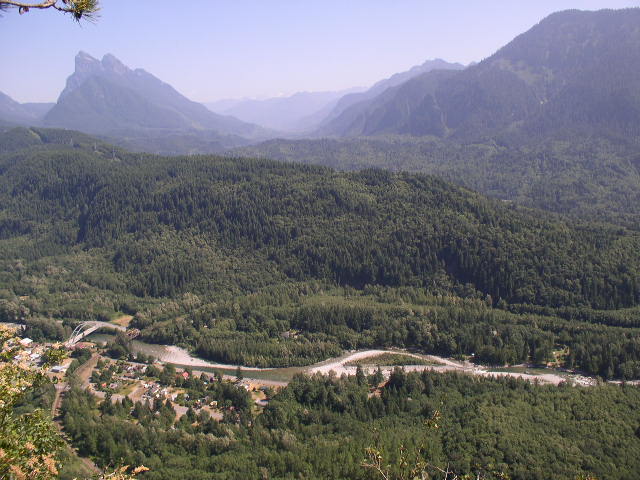 Mountain landscape with river, town, and bridge