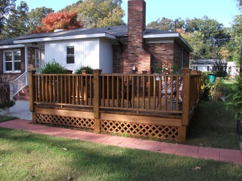 1992 Ford F-150 - A house features a large wooden deck with lattice work, a brick chimney, and a brick walkway.