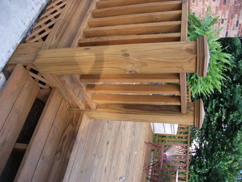 1992 Ford F-150 - A wooden deck with stairs, railing, and lattice work is shown with surrounding greenery and outdoor furniture.