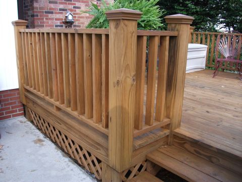 1992 Ford F-150 - A close-up view of a wooden deck railing, showing the vertical balusters, horizontal rails, and lattice skirting.