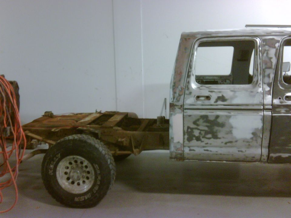 Truck cab and chassis undergoing bodywork, side view. It looks like a 1979 Ford F-250 crewcab