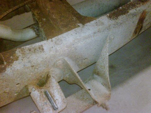 1979 Ford F-250 - Detail of a heavily rusted truck frame, showing structural components and an exhaust pipe.