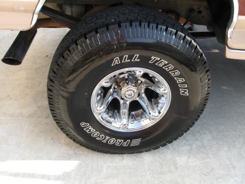 1996 Ford Bronco - This image shows a close-up of a truck's tire and chrome wheel, with 'All Terrain' and 'Pro Comp' branding visible.