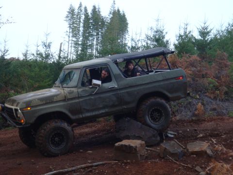 1978 Ford Bronco - A 1978 Ford Bronco navigates a rocky trail in a wooded area.