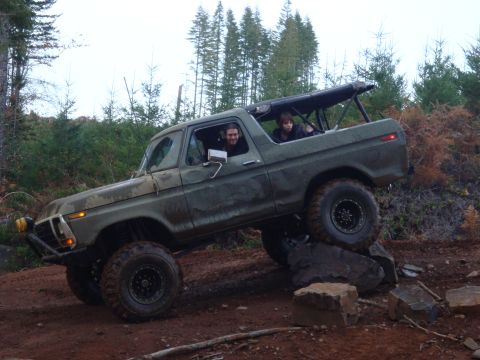 1978 Ford Bronco - A green 1978 Ford Bronco navigates a rocky trail with two occupants.