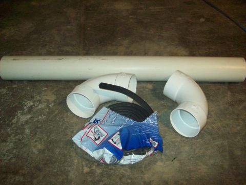 1985 Ford Bronco - PVC pipe, fittings, and gasket material are laid out on a concrete surface.