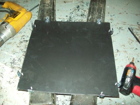1985 Ford Bronco - Tools are present next to a black panel that is attached to some metal supports.