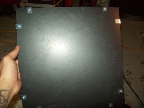 1985 Ford Bronco - A hand holds a black panel secured with bolts.