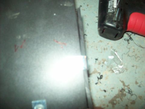 1985 Ford Bronco - A power drill and a metal panel are shown in this close-up photo.