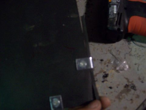 1985 Ford Bronco - A close-up view of a dark panel with metal clips, likely an interior component of a vehicle.