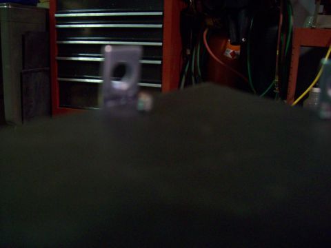 1985 Ford Bronco - A close-up view of a dark vehicle interior component with a purple bracket attached.