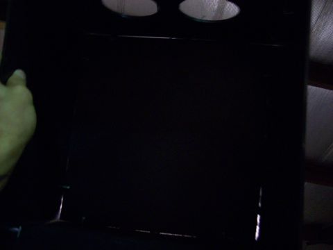 1985 Ford Bronco - A dark interior panel with two circular openings is visible, with a hand on the left side.
