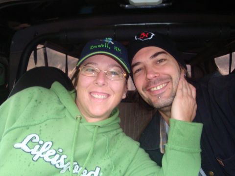 1978 Ford Bronco - A couple poses for a selfie inside a vehicle, with the woman wearing a green hoodie and a cap.