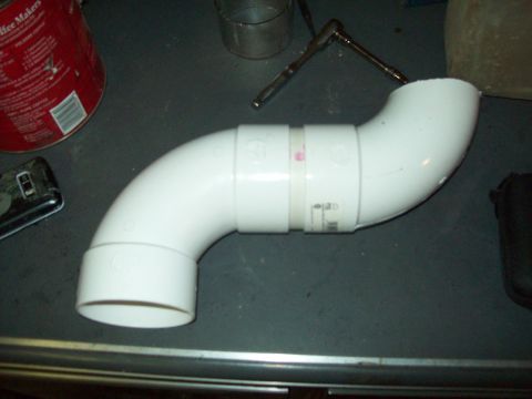 1985 Ford Bronco - A white PVC pipe assembly is shown on a dark surface, with a red can and tools in the background.