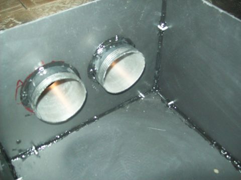 1985 Ford Bronco - Close-up view of a metal box interior, showing two threaded openings and sealant.