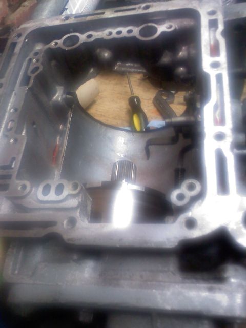 1977 Ford F-100 - Close-up view of a disassembled transmission case, showing internal components and tools.