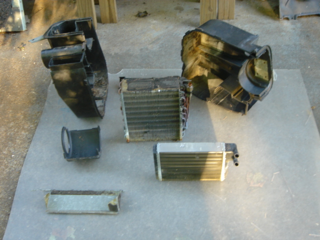 the internals: left and right heater case halves, A/C evaporator, motor shroud, heater core, and defrost deflector.